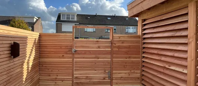 Tuin met houten poort en schermen