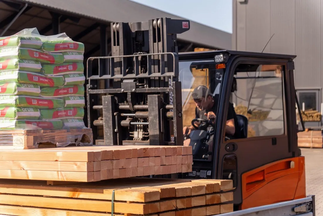 Heftruck met een pakket hout op het terrein